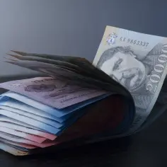 Stos banknotów, w tym węgierska waluta, z portretem mężczyzny na jednym z nich.
