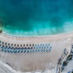Rajska plaża na Thassos z turkusową wodą i rzędami leżaków. Idealne miejsce na relaks i podziwianie pięknych widoków.