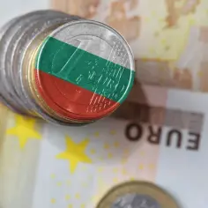 Monety z flagą Bułgarii, symbolizujące lew bułgarski, leżą na banknotach euro.