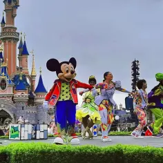 Myszka Miki i przyjaciele tańczą na scenie przed zamkiem w Disneylandzie. Gdzie jest ten magiczny świat?