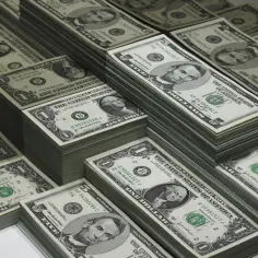 Stosy banknotów jednodolarowych i pięciodolarowych. Wyobraź sobie, że to islandia waluta, którą można by wymienić na te dolary.