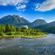 Malowniczy Dunajec płynie przez Pieniny, idealne miejsce na wakacje w Polsce. Zielone łąki, gęste lasy i skaliste szczyty tworzą zapierający dech w piersiach krajobraz.