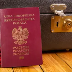 Paszport Polski obok starej walizki. Czy do Czarnogóry potrzebny jest paszport? Tak, jeśli podróżujesz z Polski.