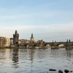 Most Karola w Pradze, z wieżą Staromiejską i kopułą kościoła. Ciekawe ciekawostki o Czechach czekają na odkrycie!