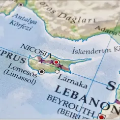 Mapa pokazuje, gdzie leży Cypr, między Turcją a Syrią, z zaznaczonymi Nikozją, Limassol i Larnaką.