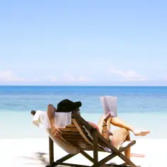 Kiedy zaczynają się wakacje, relaks na plaży z książką i widokiem na turkusowe morze.