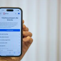 Na ekranie telefonu widoczny jest formularz do złożenia wniosku o paszport dla dziecka online na stronie gov.pl.