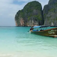 Łódź kołysze się na turkusowych wodach Maya Bay, otoczonej stromymi, porośniętymi zielenią klifami.