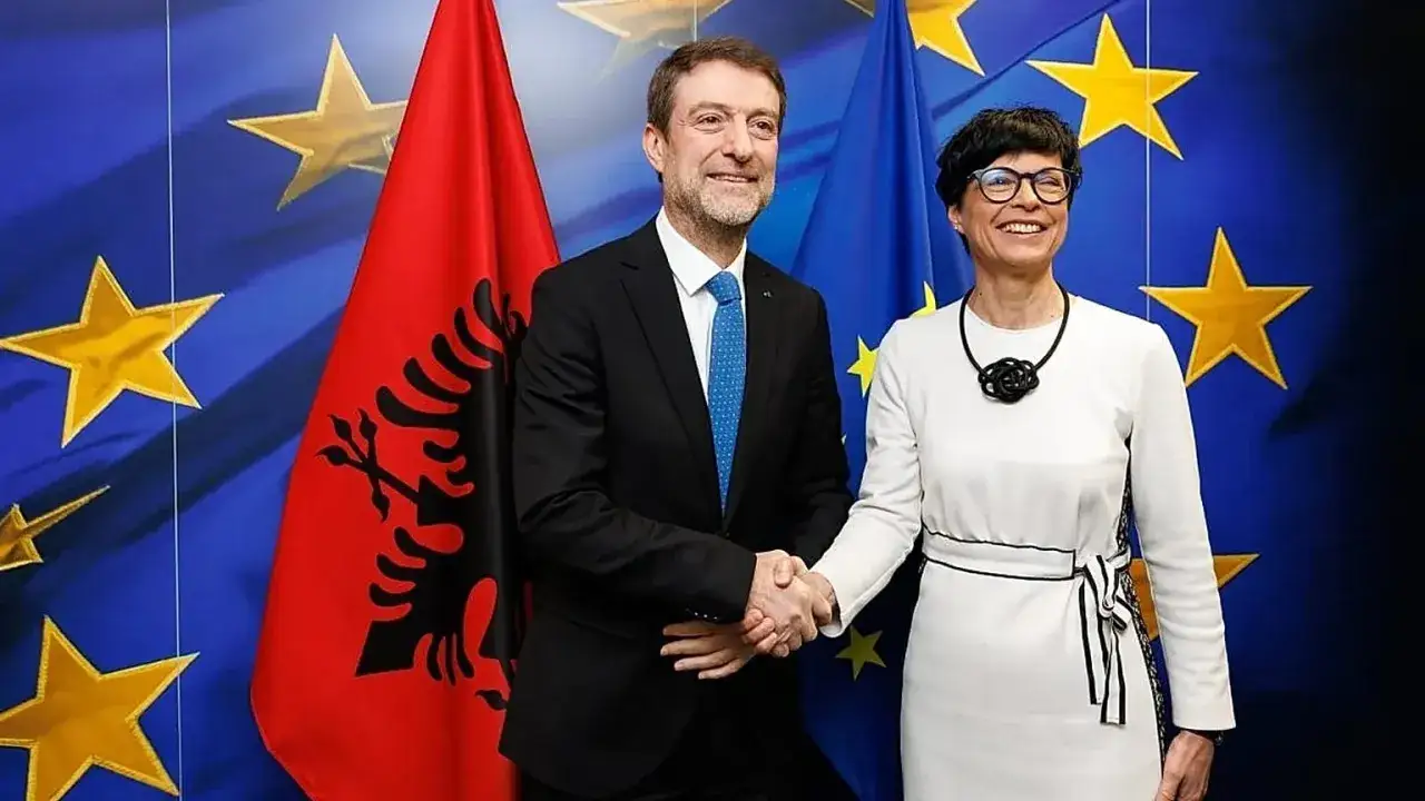 Mężczyzna i kobieta uśmiechają się, ściskając dłonie na tle flag Albanii i UE. Czy Albania jest w UE?