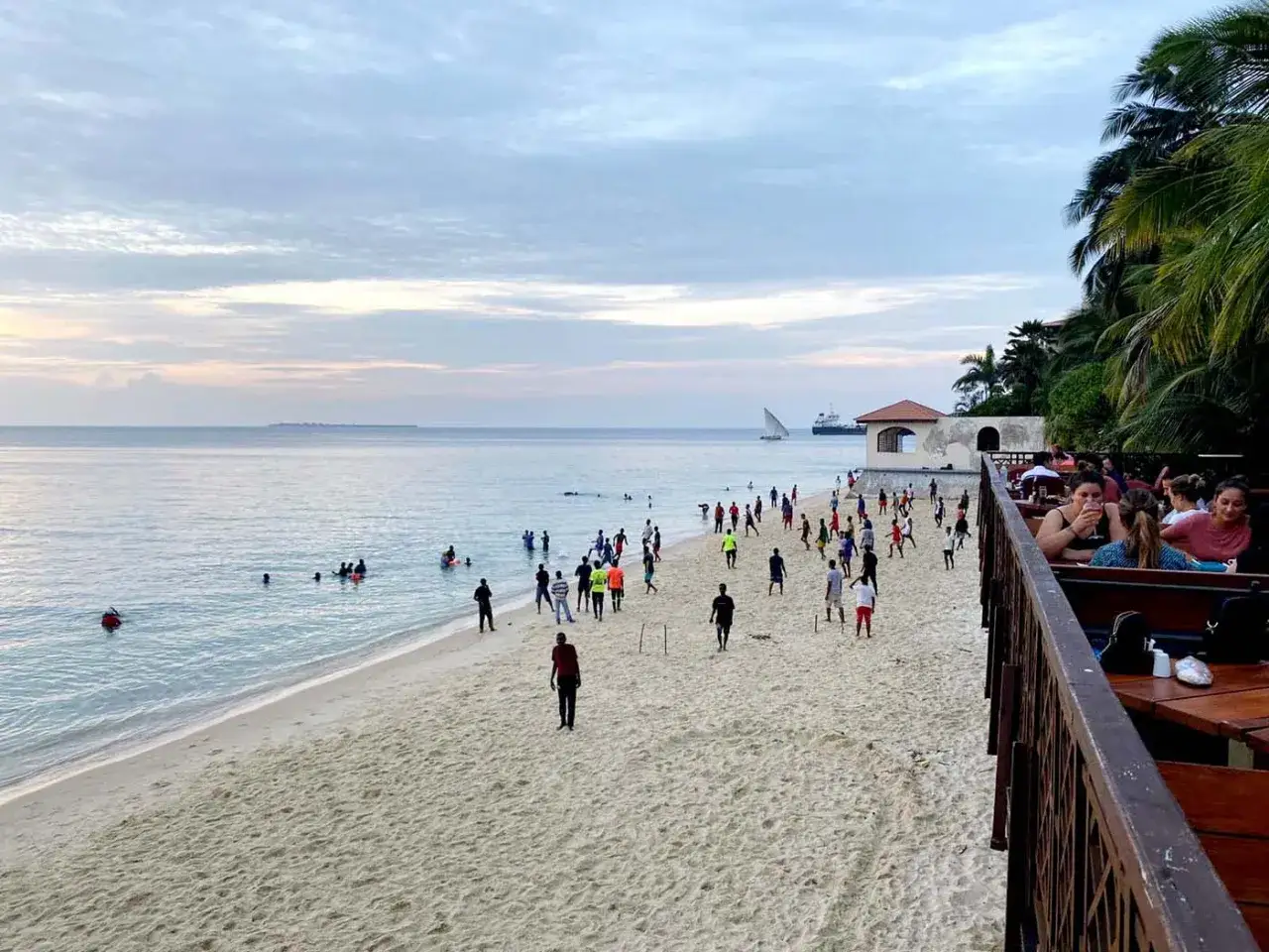 Plaża na Zanzibarze, ludzie kąpią się i grają w piłkę. Idealne miejsce na wakacje.