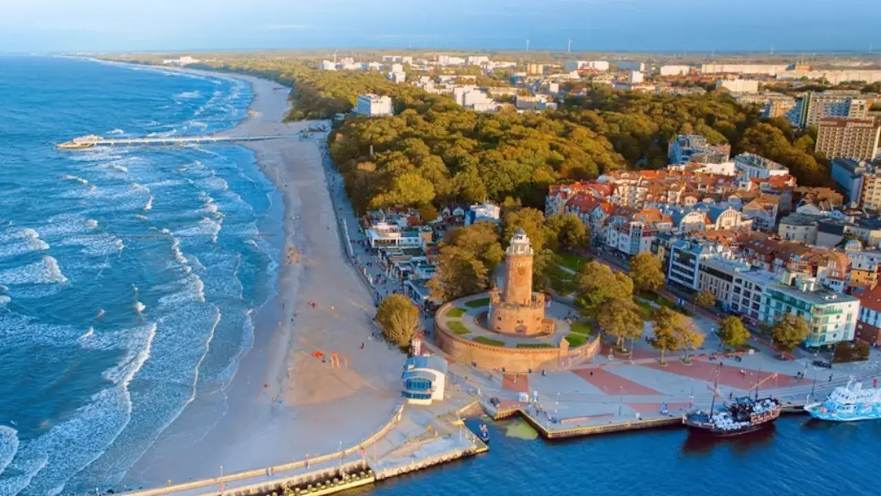 Widok na plażę, molo i latarnię morską. Idealne miejsce, gdzie nad morze można wybrać się na wakacje.