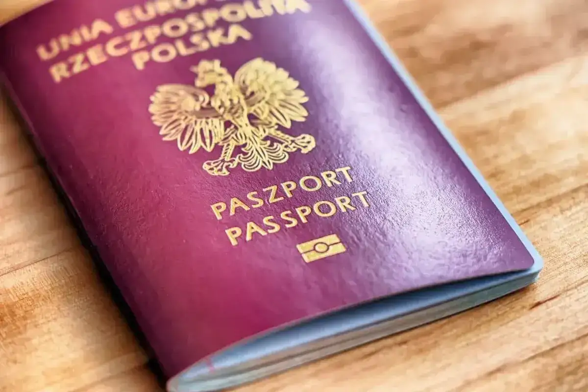 Polski paszport na drewnianym tle. Czy do Grecji potrzebny jest paszport? Tak, jeśli nie jesteś obywatelem UE.
