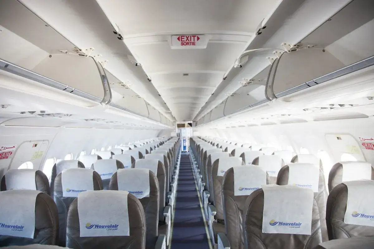 Puste siedzenia w samolocie linii nouvelair, gotowe na pasażerów.
